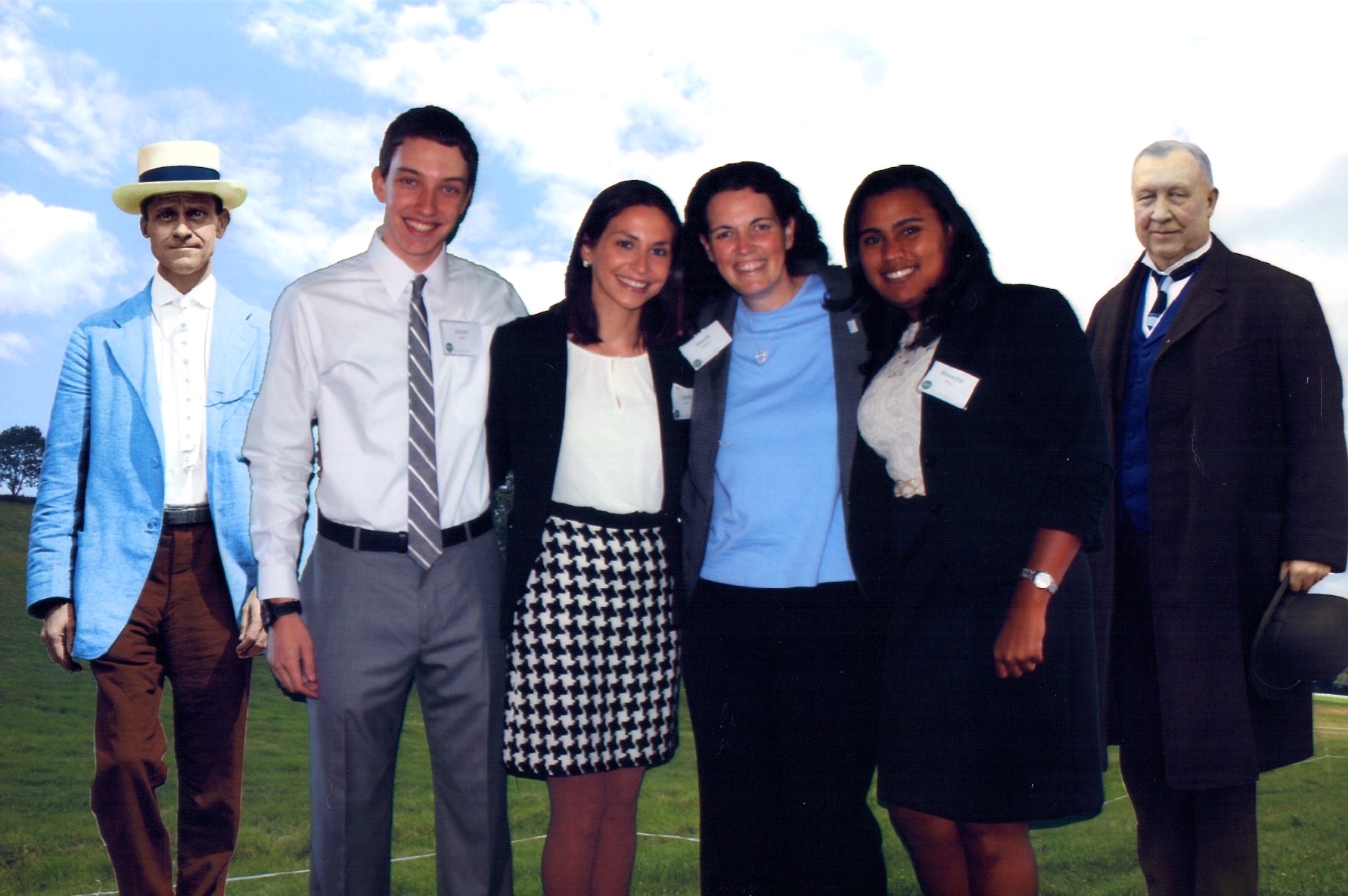group photo of four people with cardboard cutouts of two men